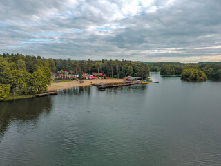 Fototapeta premium Landscape of a lake surrounded by a forest and a river flowing through the city.