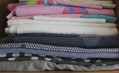 Stack of colorful folded bed linen for children on wardrobe shelf stock photo