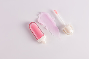 Open plastic packaging of cosmetic balm, lip gloss on light background with balm texture sample. top view. A copy space. cosmetic care