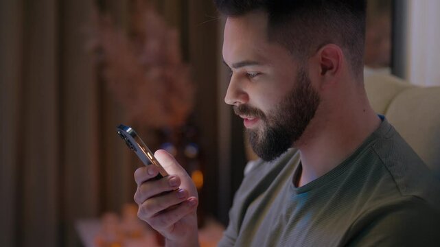 Caucasian man bed bedroom stuck mobile phone smartphone telephone technology smiling funny humor video scrolling gadget communicate social media message sms male guy internet customer connect online
