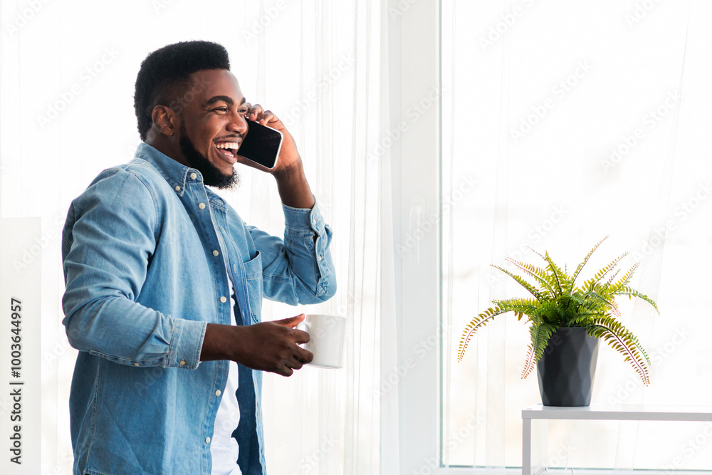 Aufkleber portrait of black millennial businessman with coffee and mobile phone enjoying view from window in m