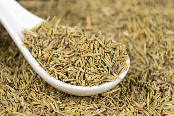 Spoon seasoning dry chopped rosemary close-up