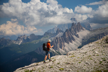 Fototapeta premium Man traveler traveling alone in breathtaking landscape of Dolomites Mounatains. Travel lifestyle wanderlust adventure concept.