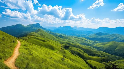 Naklejka premium A winding mountain route leading through lush green hills, with a breathtaking view of valleys and distant peaks under a clear blue sky.