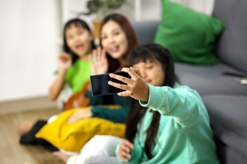 Obraz premium Happy Asian Girl Taking Selfie With Her Mother And Younger Sister At Home