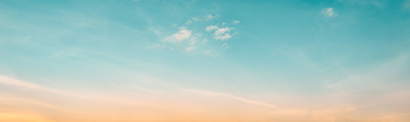 The clear teal blue sky with white clouds provides a bright and sunny background, enhancing the natural beauty of the landscape on this pleasant summer day