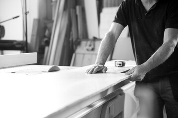 Carpenter working on wood in workshop. - black n white -