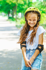 Portrait of a smiling child girl skateboarder wearing helmet, elbow and knee support for body safety protect.