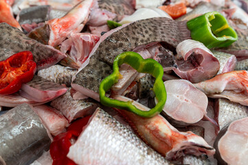 Fresh fish and vegetables prepared for cooking at a bustling market in the city
