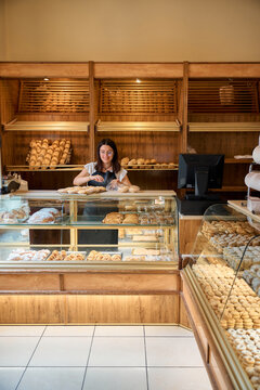 Baker arranging fresh pastries in a cozy bakery during morning hours