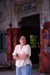 Naklejka premium A woman with a scared expression is standing in an abandoned, creepy train station