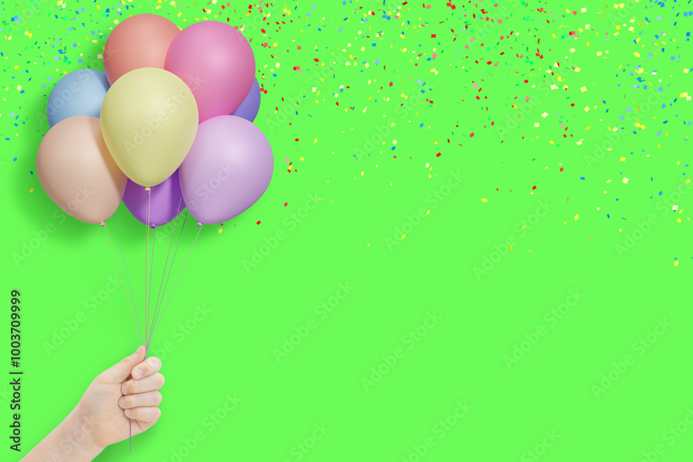 Poster female hand holding bunch of shiny colorful balloons on summer green background with confetti. empty