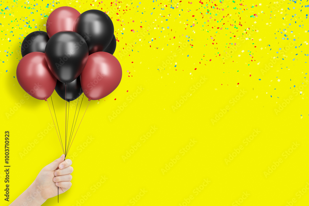 Poster female hand holds bunch of red and black balloons on yellow background with confetti. empty space fo