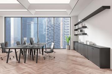 Modern coworking interior with tables and pc desktop, panoramic window