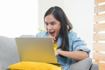 Amazed woman excited when looking at crazy sale deal news in laptop.