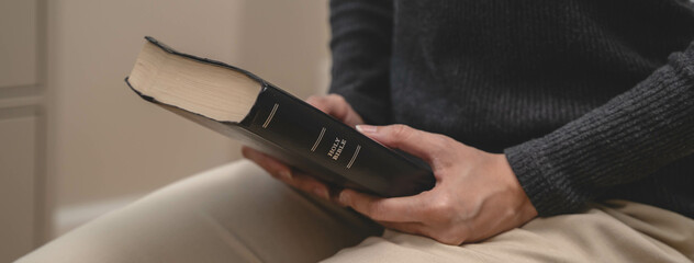 Christian praying worship to god and holding bible book in her hand