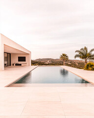 Fototapeta premium Modern villa with a serene swimming pool and scenic views in a tranquil landscape during daytime
