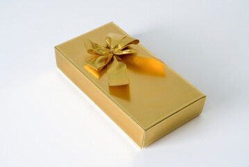 A gold box with a bow on top of it. Close up