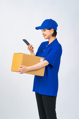 荷物とスマホを持つ作業服を着た女性　デリバリースタッフ　配達員　作業員　切り抜き全身写真