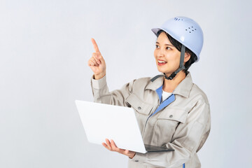 パソコンを持つヘルメットと作業服を着た女性　作業員　エンジニア