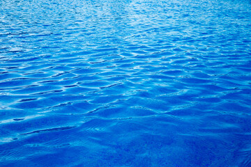 Obraz premium Water in swimming pool rippled water detail background. Blue in the water in the swimming pool.