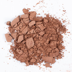 Scattered brown eyeshadow on a white background. Eye shadow texture