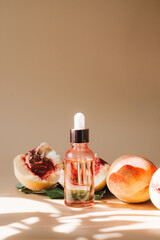 Natural cosmetics, hair and skin care. Organic oil. Bottle with essential oil and fresh peaches on beige background. High quality photo