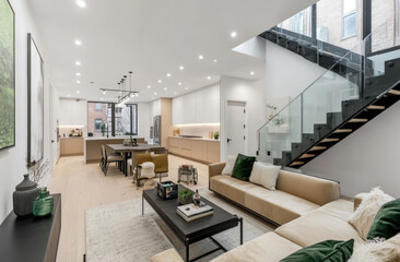 Fototapeta premium Wide shot of a modern living room with white walls, an open-concept kitchen and dining area in the background