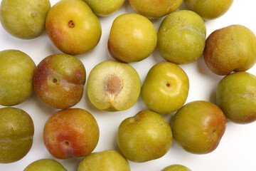 Ripe sweet small mini plum green maroon on white background