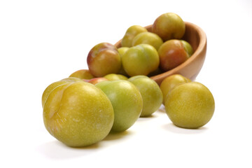 Ripe sweet small mini plum green maroon on white background