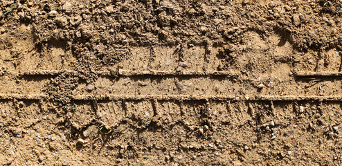 Sand tyre mark background. Tire track shape. Trail lines on dry brown sand pattern. Road construction site backdrop. Heavy machinery imprint. Dried mud vehicle wheel shape.