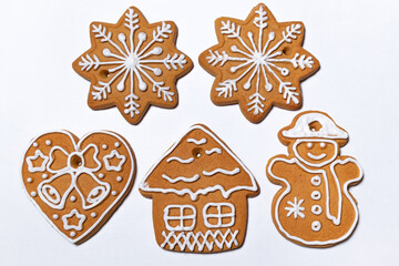 Ready-to-eat gingerbread cookies close-up on a white background. Christmas cookies of different shapes decorated and covered with white sugar icing