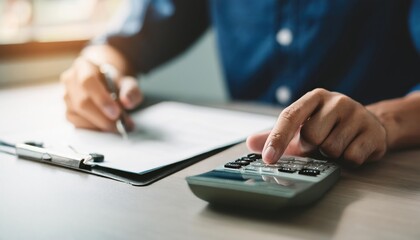 close up young man hand press on calculator to check and summary expense of home loan mortgage 