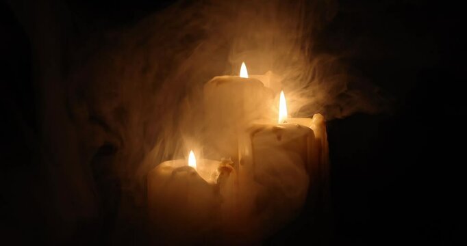 Lit candle flame through heavy smoke fog mist vapour flow twist beautiful mistic