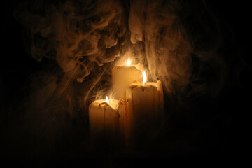 Lit candle flame through heavy smoke fog mist vapour flow twist beautiful mistic