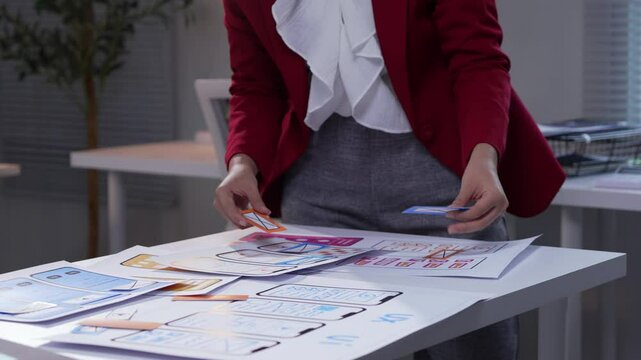 Ux designer is arranging cards on a table to design the customer journey of a mobile application