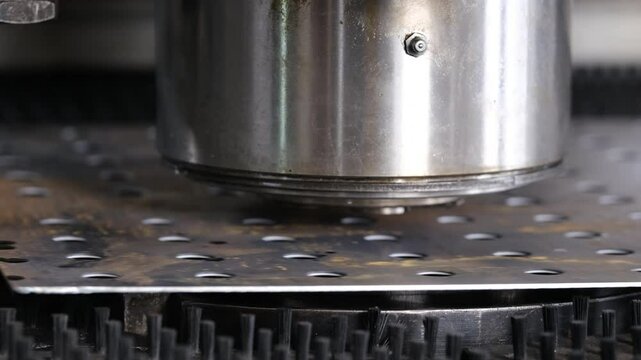 A large industrial punch press forming high precision metal parts. Metal bending machine on a modern industrial factory.
