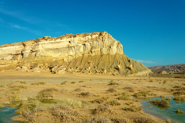 Clay remnants turn the area into a yellow-brown clay country. Clay-colored puddles after rain, Qeshm, Iran
