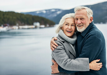 Portrait of happy scandinavian senior couple embracing each other in front of the nordic winter sea
