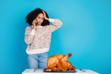 Photo portrait of lovely young lady confused upset talk phone celebrate thanksgiving dinner turkey isolated on blue color background