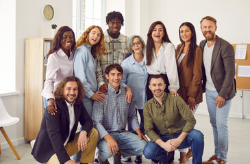 Happy diverse business team gather together at work in office. Group portrait of cheerful young and...