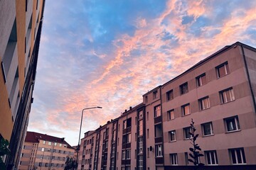 street with houses in the morning, sky with pink clouds at dawn