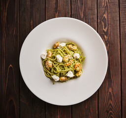 Delightful plate of pasta with fresh shrimp and creamy ricotta served on a rustic wooden table