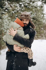 Portrait of happy family: Father and baby daughter on Winter Vacation in park. Happy, joyful family