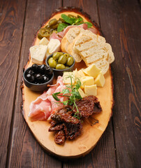 A vibrant charcuterie board filled with artisanal cheeses, cured meats, olives, and fresh herbs on a rustic wooden platter