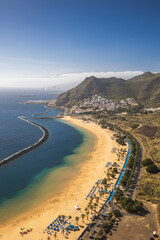 Playa de Las Teresitas captured on a warm sunny day, with the Teide volcano visible in the background.