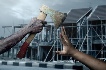 Zombie hand with bloody wound holding axe with midnight background. Scene has dark and scary. Zombie hand swings the axe to the man, creating a tense and dangerous atmosphere