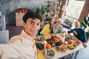 Photo of happy family celebrate thanksgiving young teen grandson take selfie photo holiday dinner relatives living room celebrate weekend