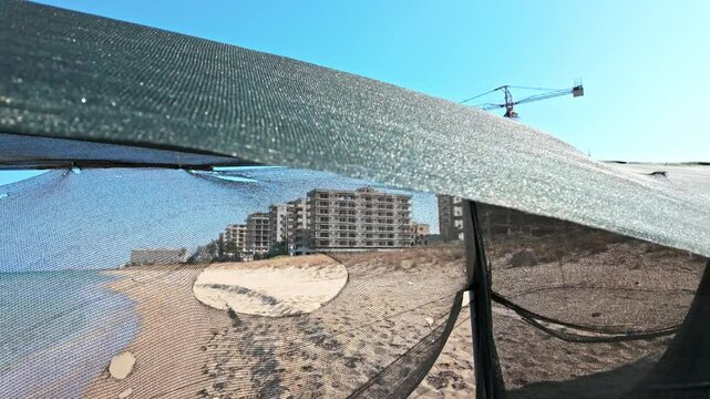 Abandoned beachfront buildings under clear skies with a sandy shoreline in Varosha, Cyprus