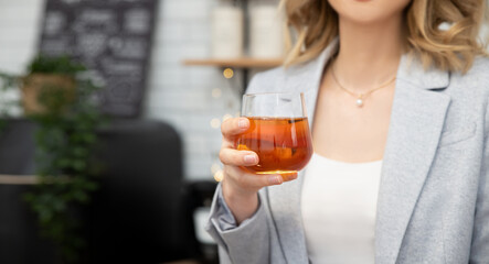 Woman holds a glass of juice or other beverage in her hands. Concept of Healthy Eating, Diets and Nutrition. Selective focus, Close Up